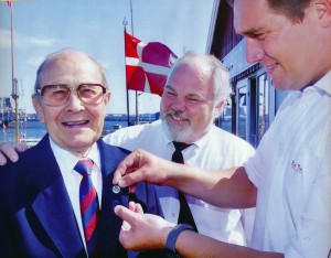 En glad og stolt Frank Pedersen får Dansk Idræts Forbunds ærestegn i 2002. I midten Aalborg Roklubs formand Gregers S. Gregersen. Til højre bestyrelsesmedlem i DIF tidligere mestersvømmer Benny Nielsen